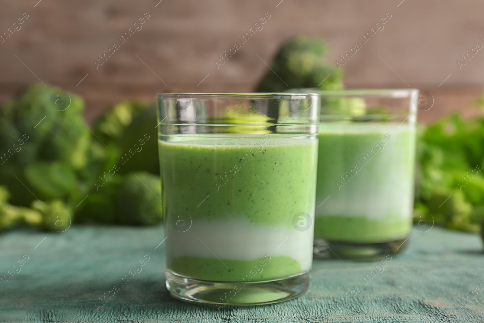 Photo of Glasses with healthy detox smoothie and ingredients on table