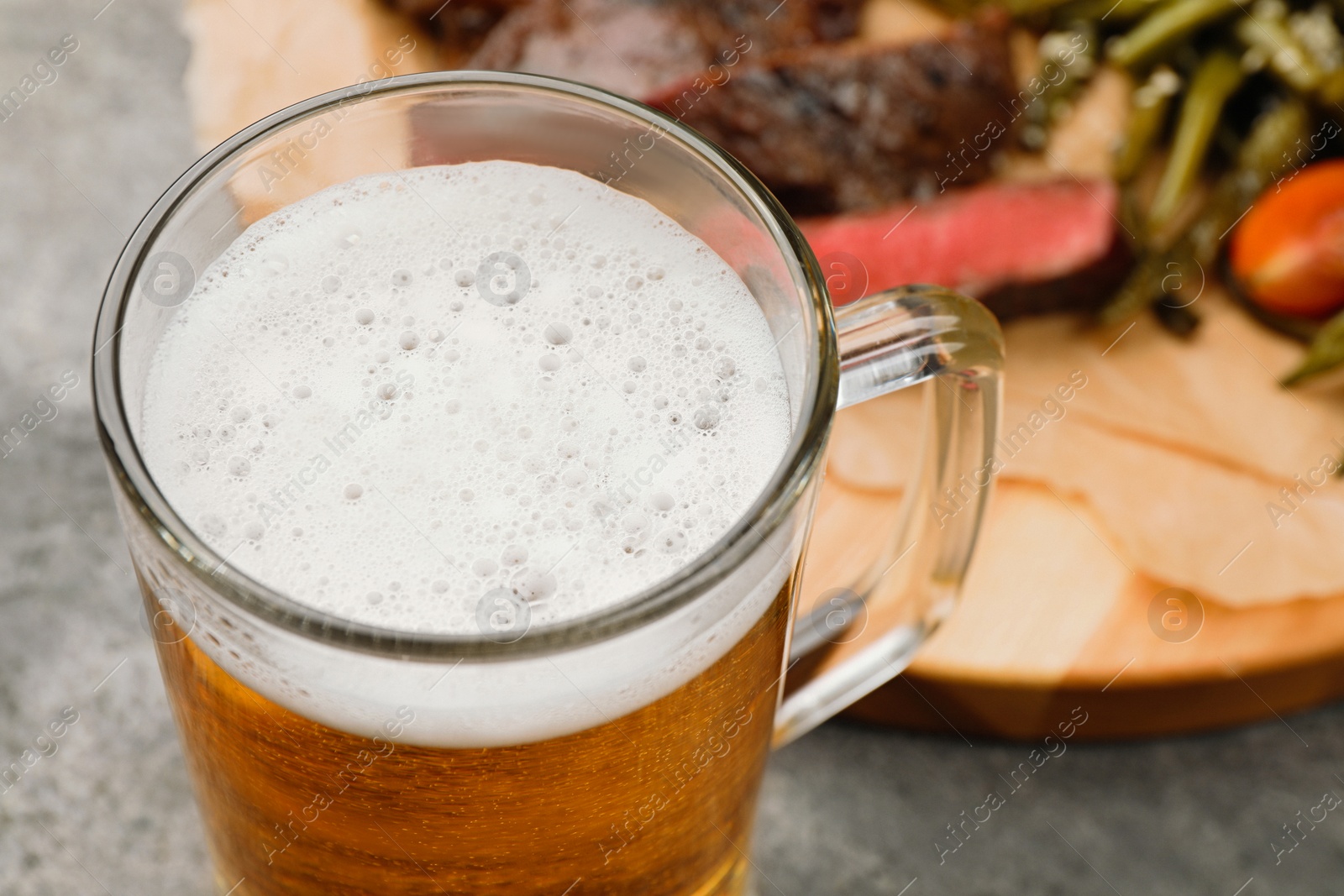 Photo of Glass mug with tasty beer on table, closeup