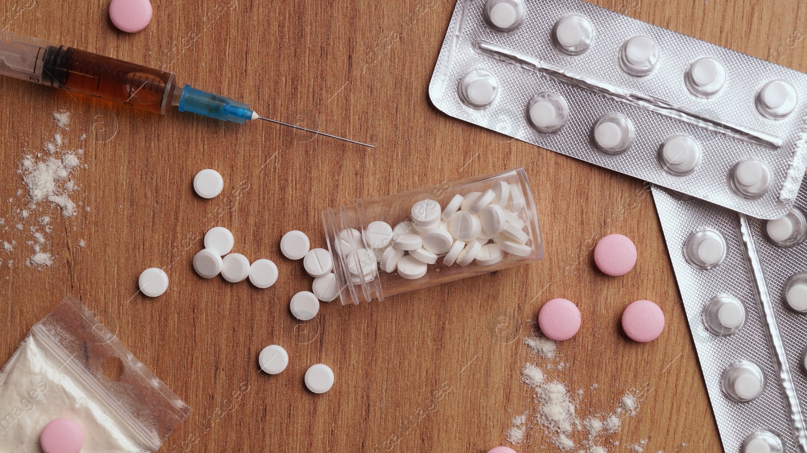 Photo of Different hard drugs on wooden table, flat lay