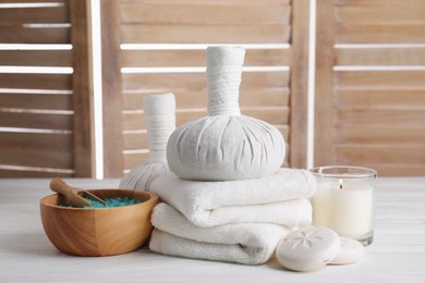 Photo of Spa composition with skin care products and burning candle on white wooden table