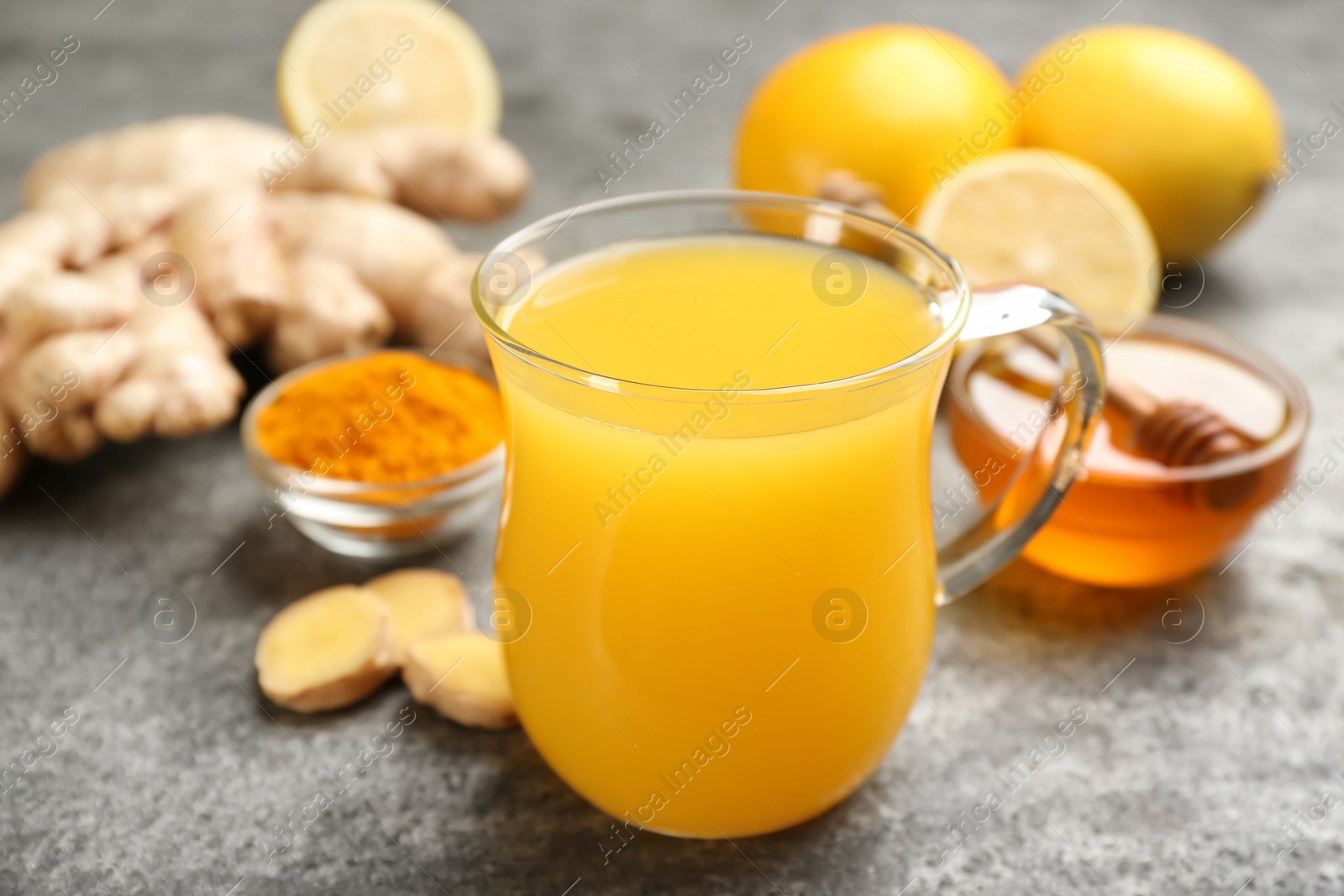 Photo of Immunity boosting drink and ingredients on grey table, closeup