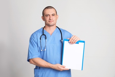 Photo of Portrait of medical assistant with stethoscope and clipboard on color background. Space for text