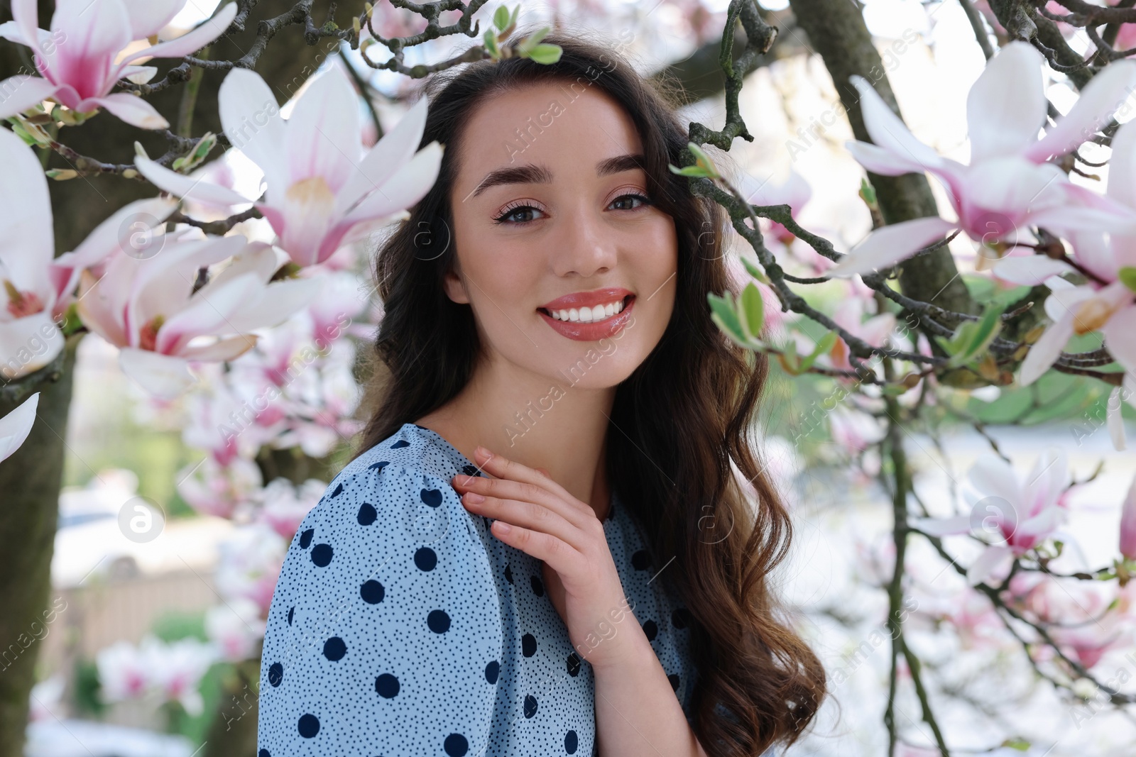 Photo of Beautiful woman near blossoming magnolia tree on spring day