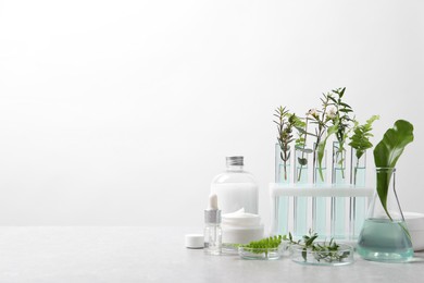 Photo of Organic cosmetic product, natural ingredients and laboratory glassware on white table, space for text
