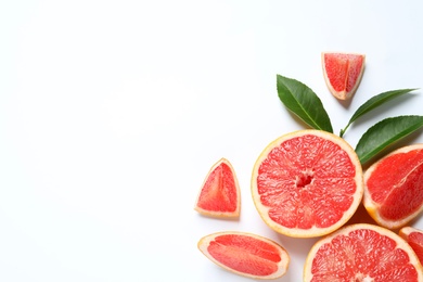 Grapefruits and leaves on white background, top view. Citrus fruits