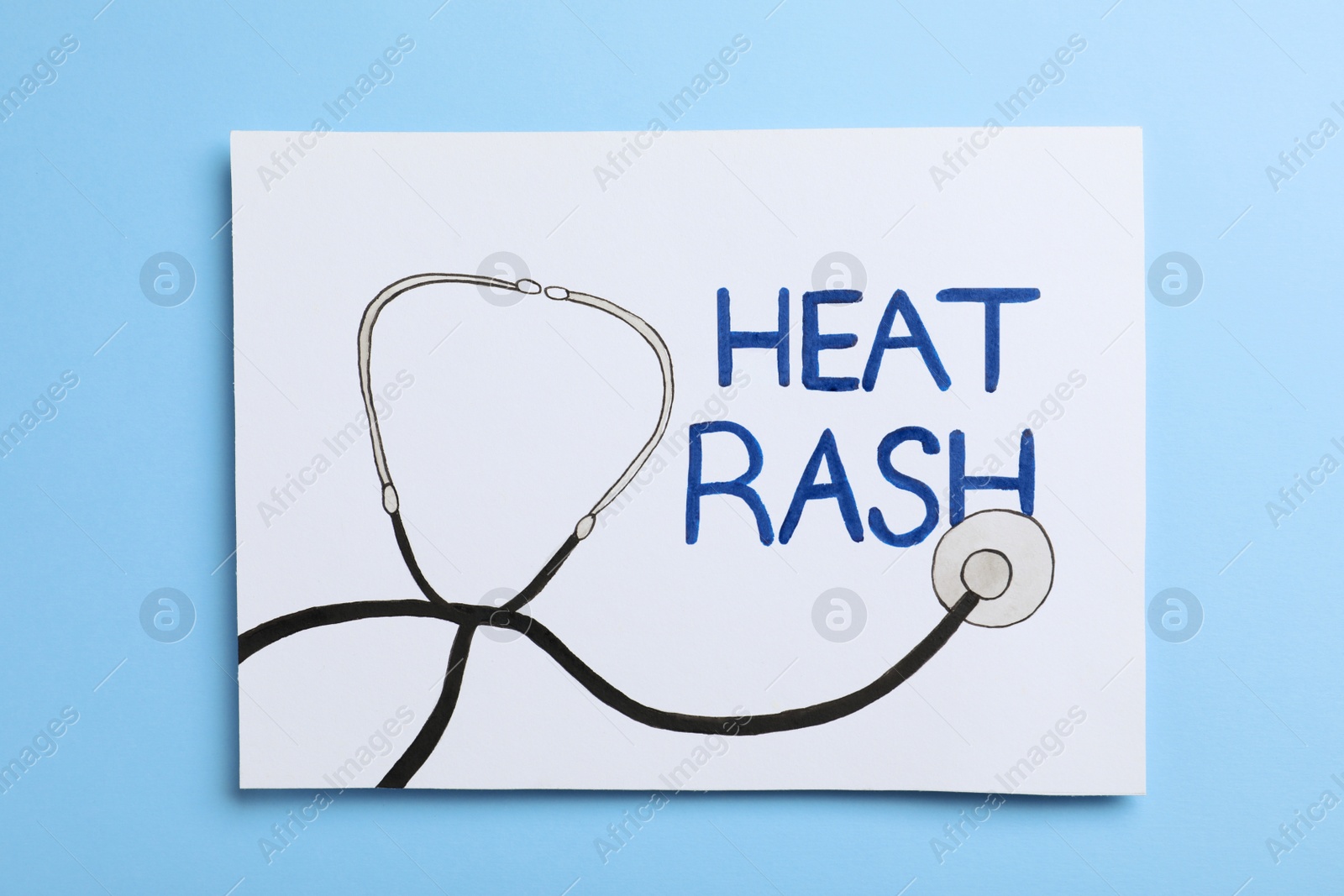 Photo of Sheet of paper with words Heat Rash and drawn stethoscope on light blue background, top view