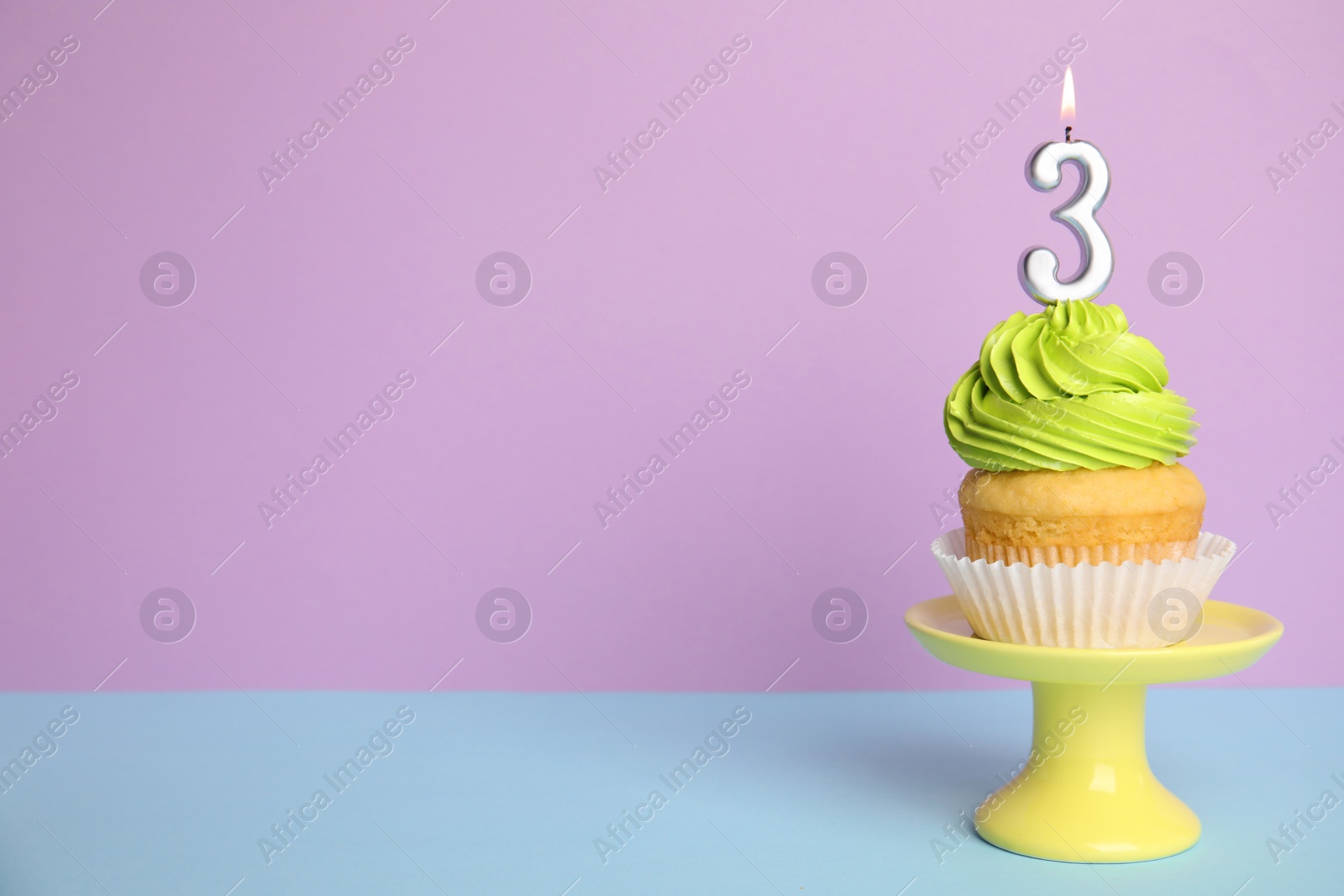 Photo of Birthday cupcake with number three candle on stand against color background, space for text