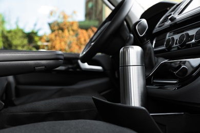 Photo of Silver thermos in holder inside of car