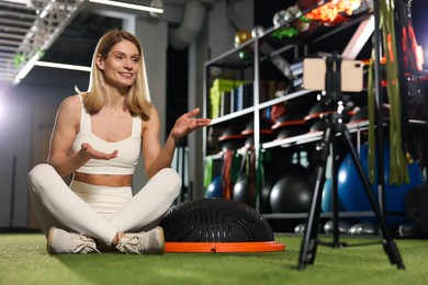 Fitness trainer recording online classes in gym