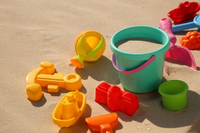 Photo of Set of plastic beach toys on sand, space for text. Outdoor play