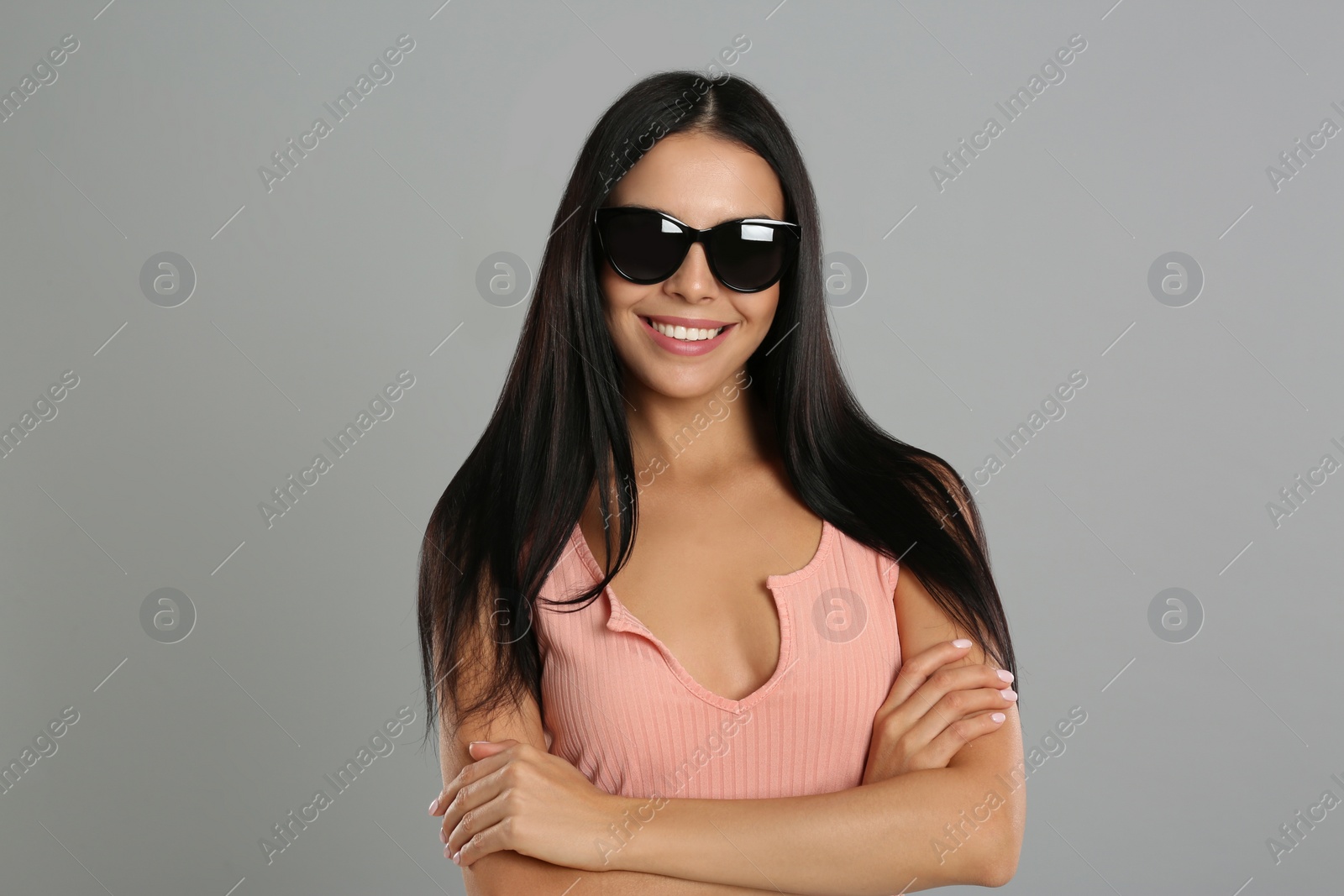 Photo of Beautiful woman wearing sunglasses on grey background