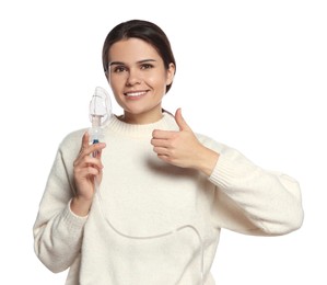 Photo of Happy young woman with nebulizer showing thumb up on white background