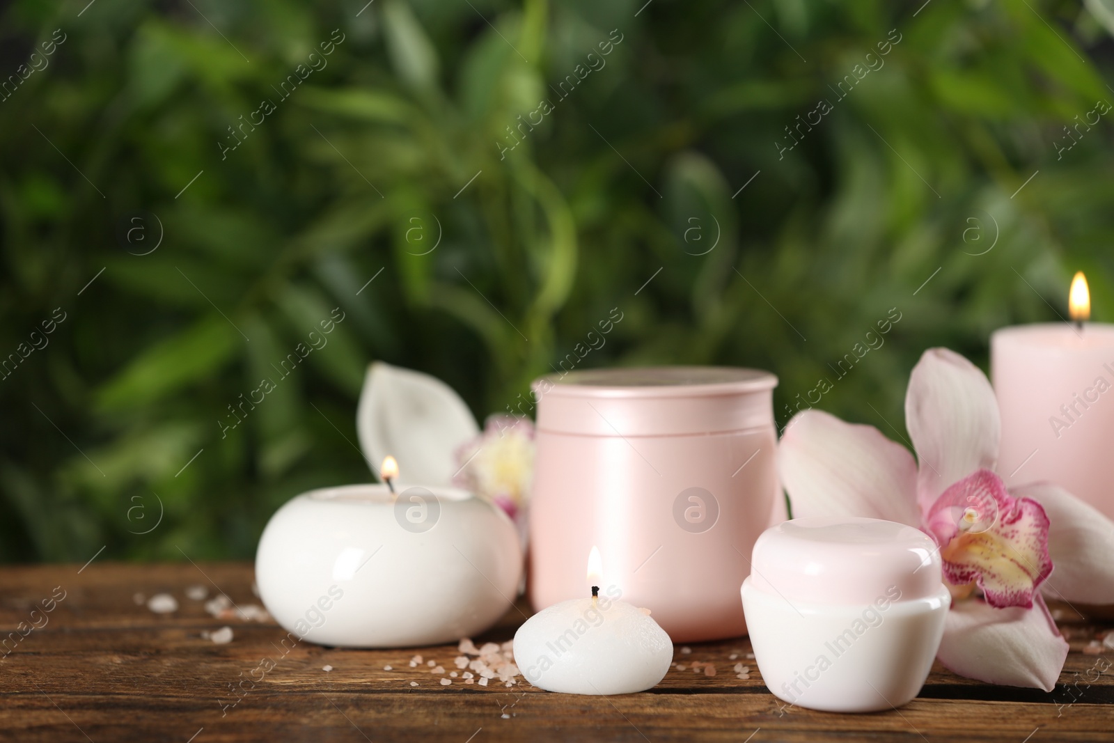 Photo of Beautiful spa composition with skin care products and candles on wooden table