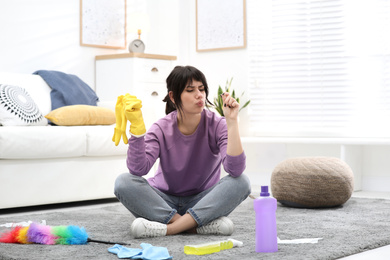 Photo of Lazy woman procrastinating while cleaning at home