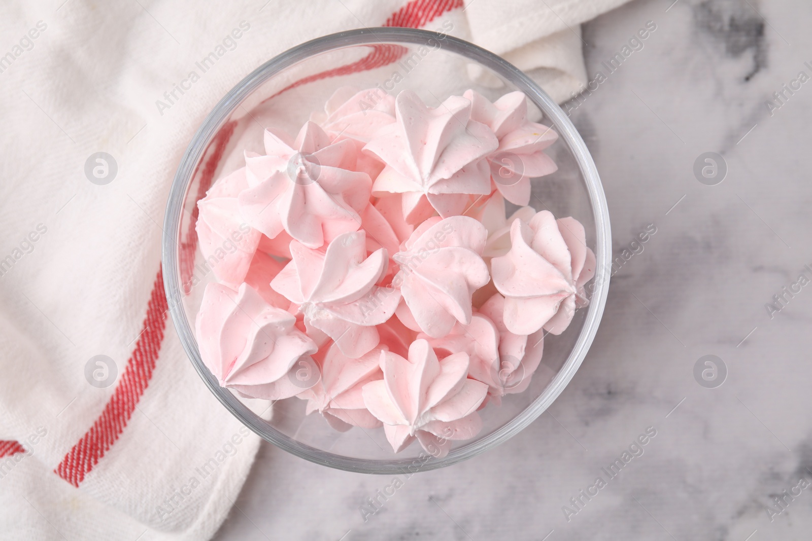 Photo of Tasty meringue cookies in bowl on white marble table, top view