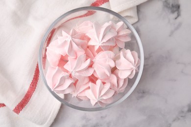 Photo of Tasty meringue cookies in bowl on white marble table, top view