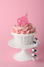 Photo of Baby shower cupcake with topper on pink background