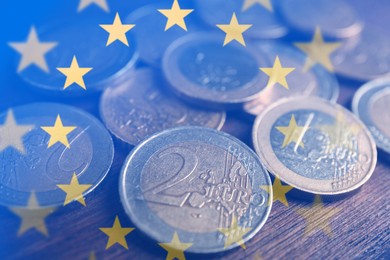 Double exposure of European Union flag and coins on wooden table, closeup view