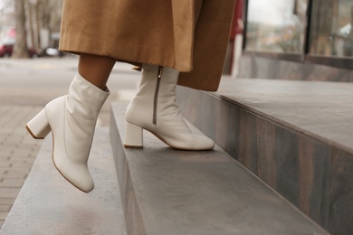 Photo of Woman wearing stylish leather shoes on stairs outdoors, closeup