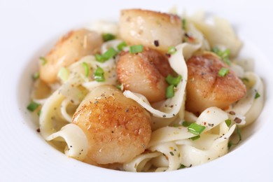 Photo of Delicious scallop pasta with spices in bowl, closeup
