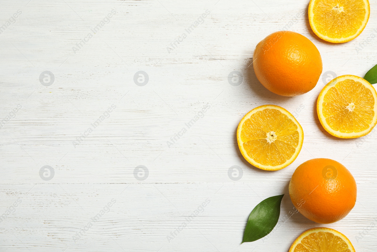 Photo of Flat lay composition with fresh oranges on wooden table. Space for text