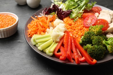 Photo of Balanced diet and healthy foods. Plate with different delicious products on black table, closeup