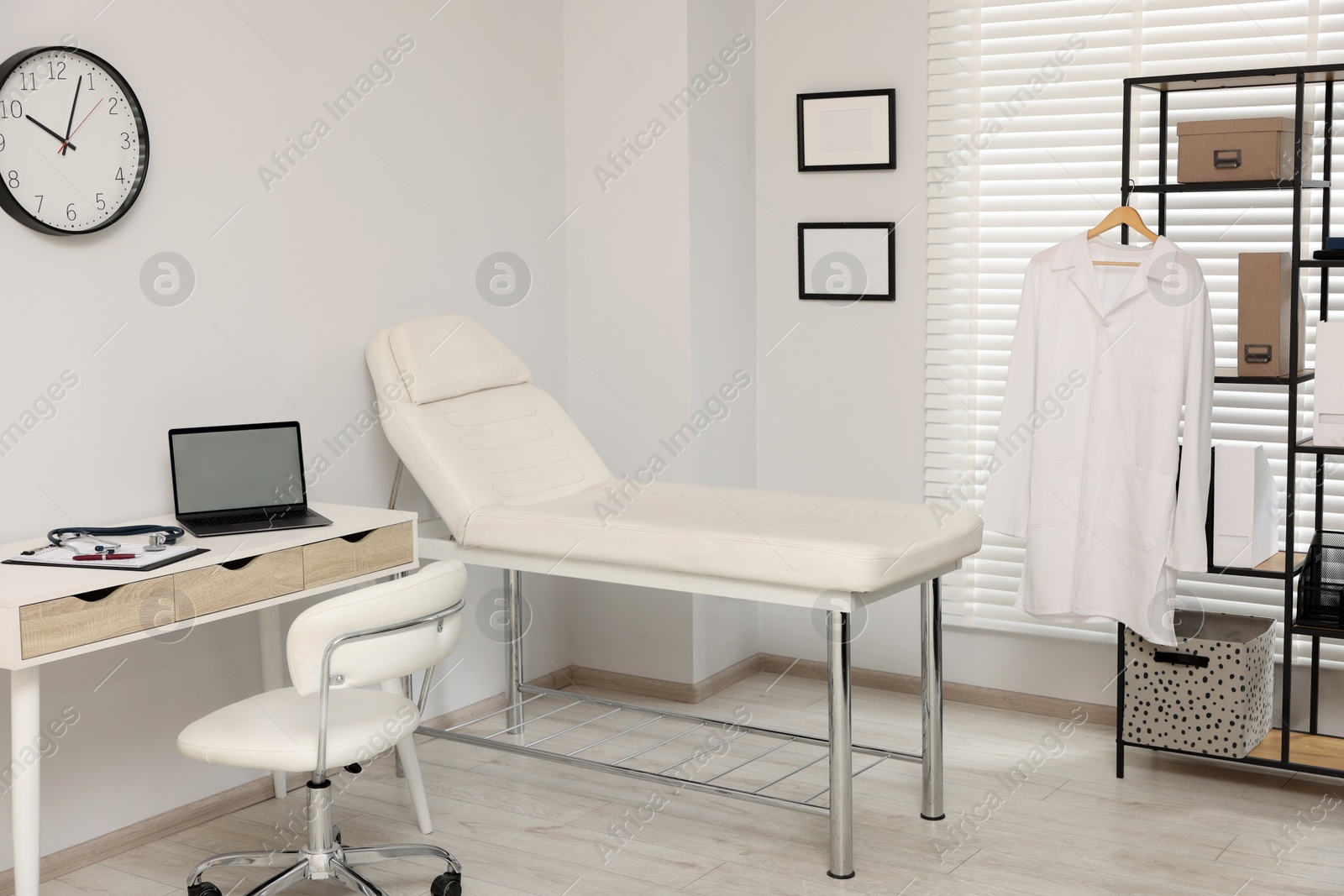 Photo of Modern medical office with doctor's workplace and examination table in clinic