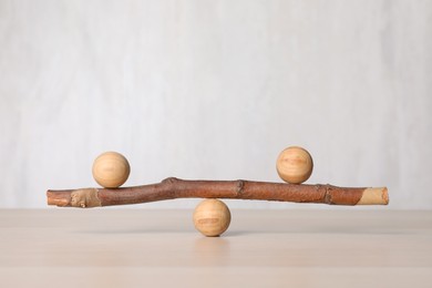 Photo of Tree branch with wooden balls on table, space for text. Harmony and balance concept