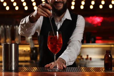 Bartender making fresh alcoholic cocktail at bar counter, closeup