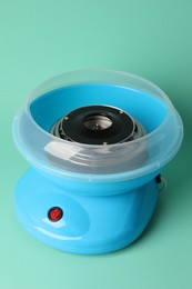 Portable candy cotton machine on turquoise background