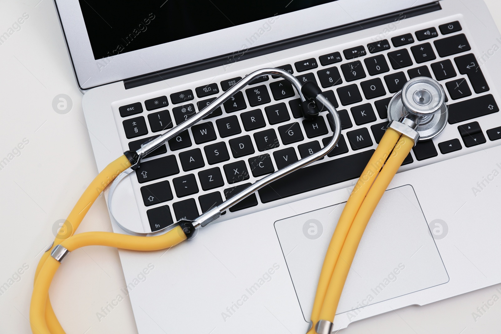 Photo of Modern laptop and stethoscope on table. Technical support concept