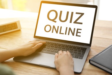 Image of Woman using modern laptop for taking quiz online at table, closeup