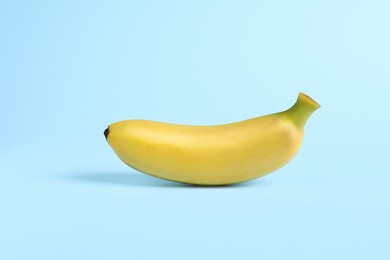 Photo of One sweet ripe baby banana on turquoise background