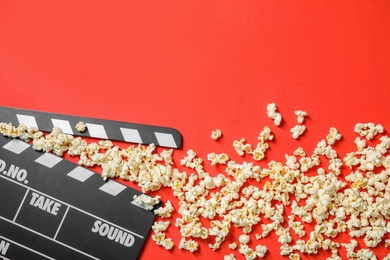 Photo of Popcorn and clapperboard on color background, top view with space for text. Cinema snack