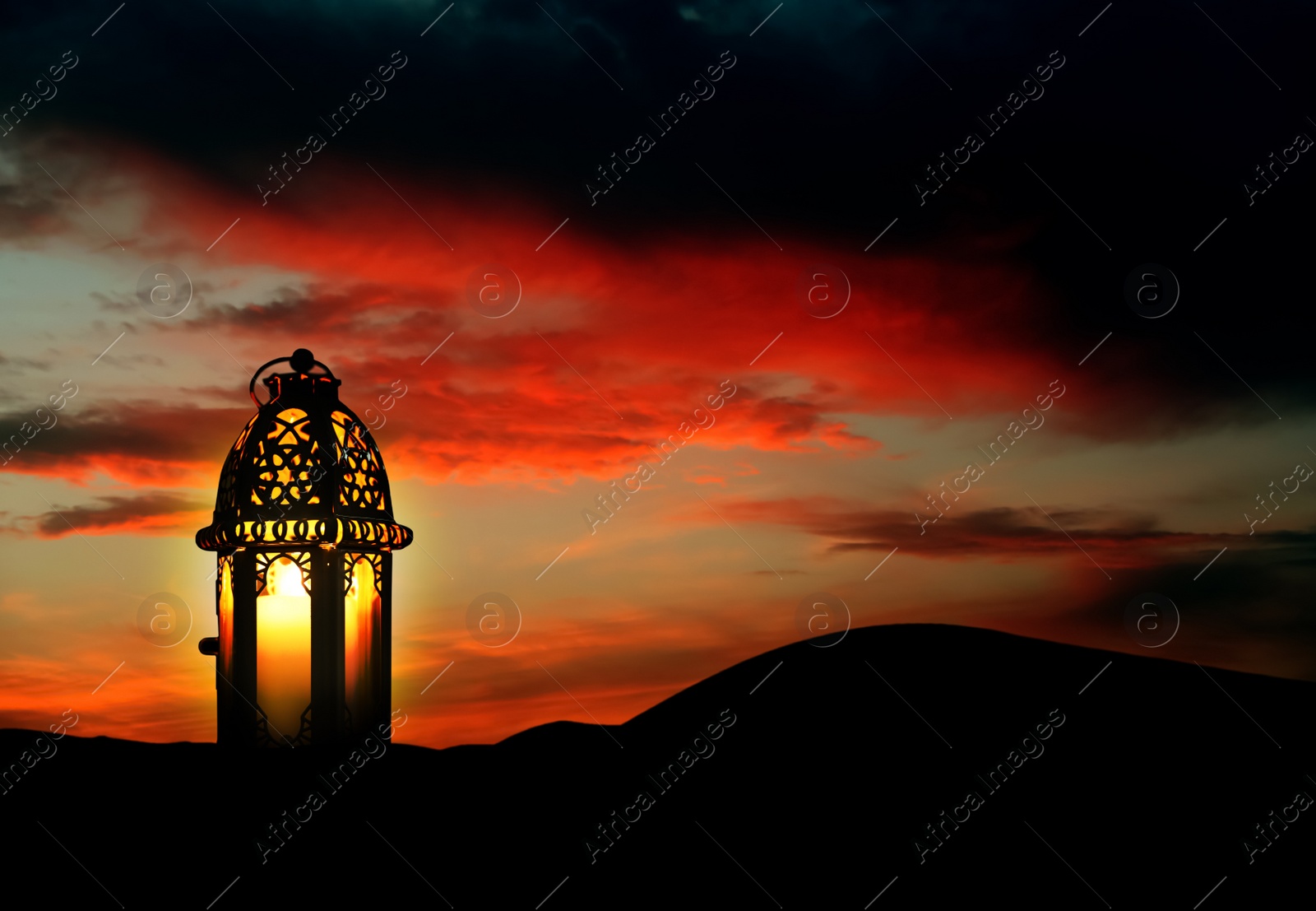 Image of Beautiful Arabic lantern on sand at sunset, space for text