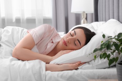 Beautiful young woman sleeping in soft bed at home