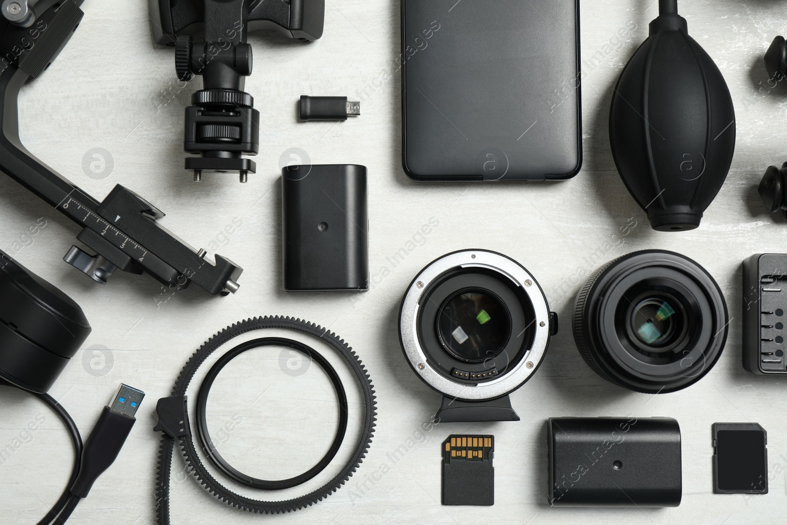 Photo of Flat lay composition with camera equipment and accessories for video production on light background