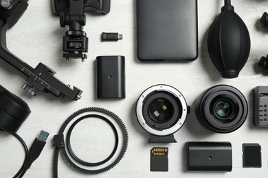 Flat lay composition with camera equipment and accessories for video production on light background