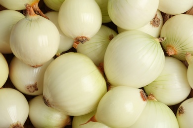 Photo of Fresh whole onions as background, top view