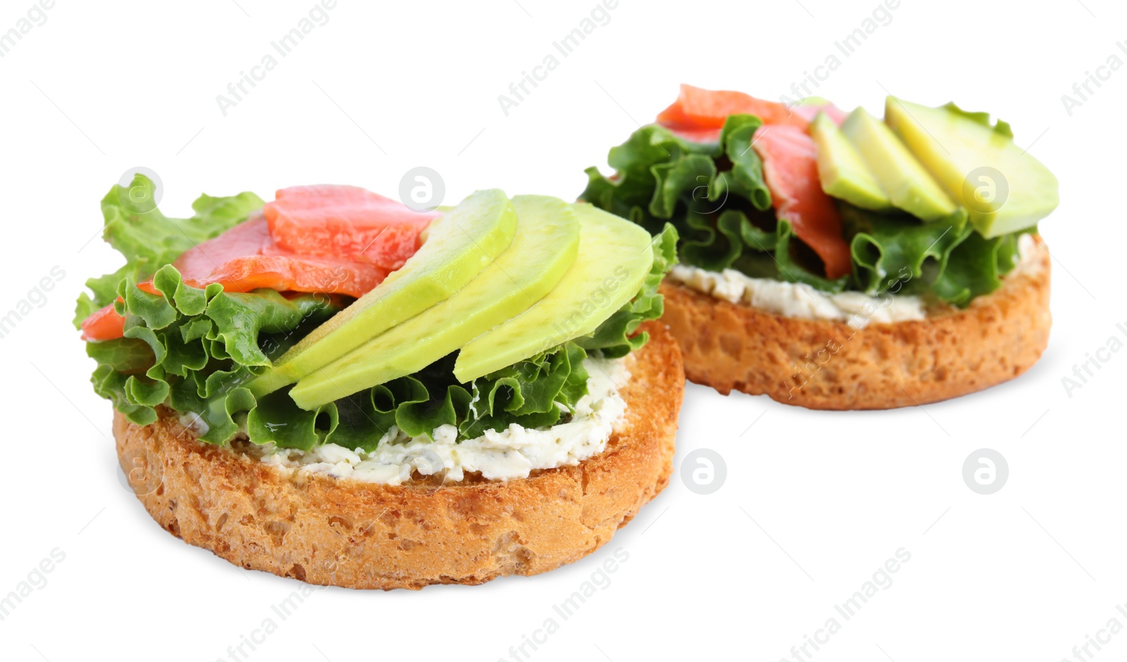 Photo of Tasty rusks with salmon, cream cheese and avocado isolated on white