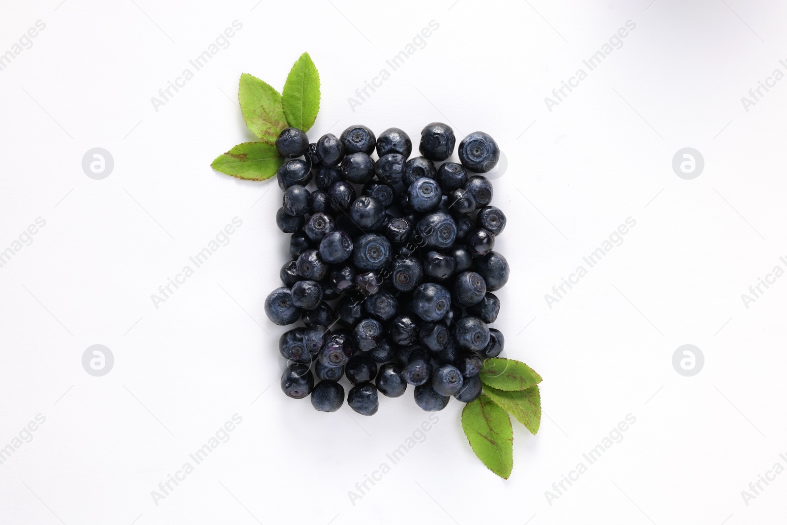 Photo of Ripe bilberries and leaves on white background, flat lay