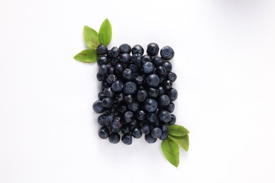 Photo of Ripe bilberries and leaves on white background, flat lay