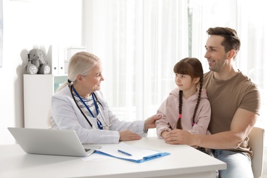 Photo of Father with child visiting doctor in hospital