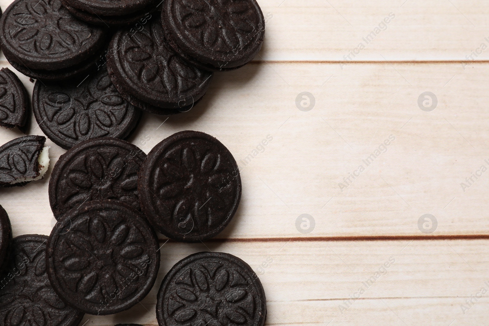 Photo of Tasty sandwich cookies on light wooden table, flat lay. Space for text