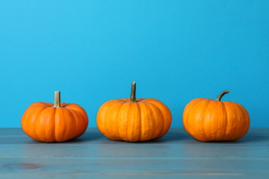 Fresh ripe pumpkins on turquoise wooden table, space for text