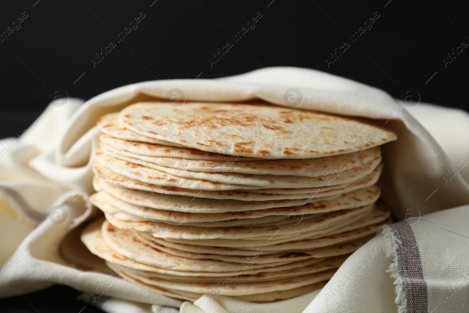 Photo of Stack of tasty homemade tortillas on table