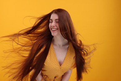 Portrait of smiling woman on yellow background