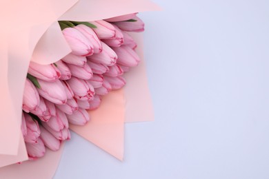 Photo of Bouquet of beautiful pink tulips on light grey background, above view. Space for text