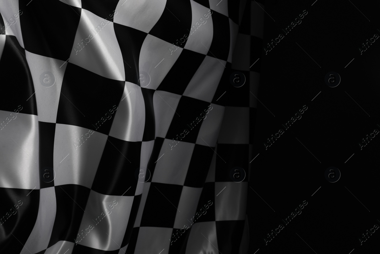 Photo of Checkered flag on black background, space for text