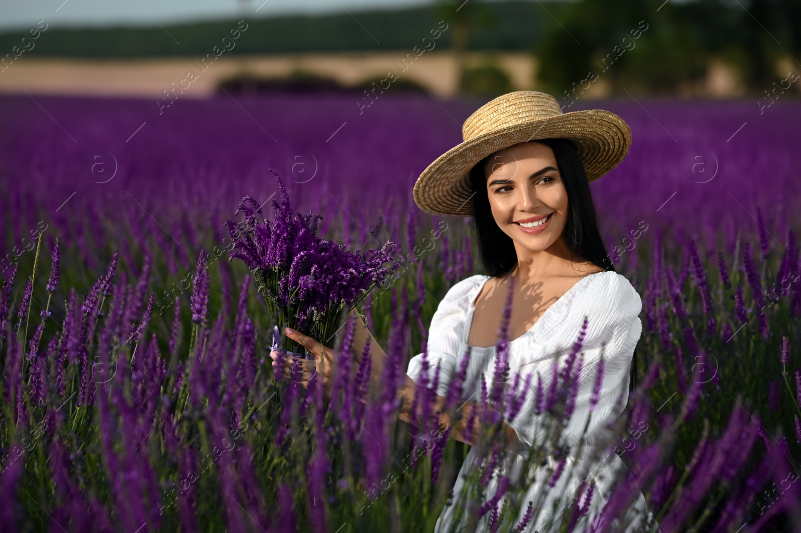 Photo of Beautiful young woman with bouquet in lavender field